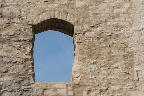 Window opening in old stone wall under blue sky Stock Photos