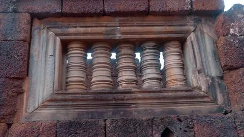 A window opening with stone carved balusters in the ancient ruined wall  Stock Footage 318724070