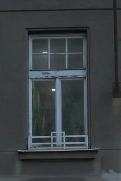A window positioned on the side of a building, featuring a white frame Fotos de archivo