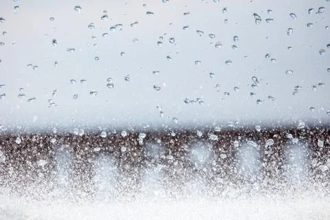 Window with rain and snow falling outside, blurred background Stock Photos
