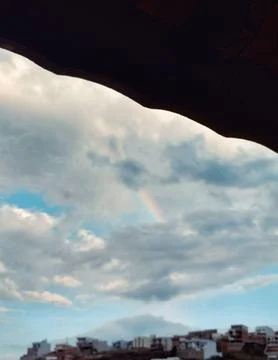 From the window, a rainbow between clouds Stock Photos