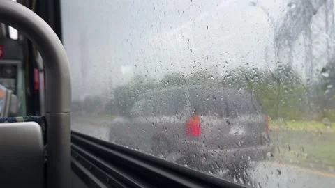 Window with raindrops on a bus driving through the city streets on a rainy day. Stock Footage 254919077