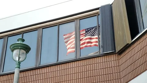 Window Reflection of American Flag Waving Stock Footage 153338798