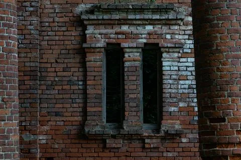 The window of the ruined red brick stable. 19th century buildings. Stock Photos