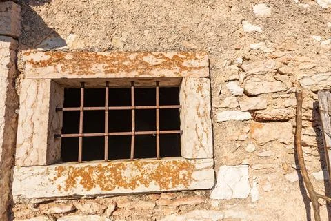Window with Rusty Iron Security Bars of an old Stone Cowshed - Italy Stock Photos