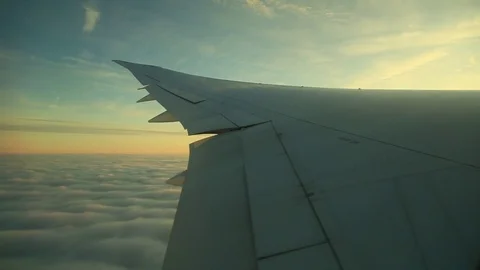 Window seat view of airline jet wing during a golden sunset. Video stock 83653840