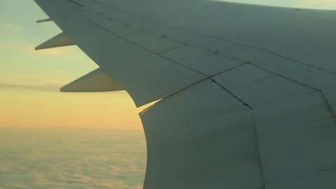 Window seat view of airline jet wing during a golden sunset. 動画素材 83653955