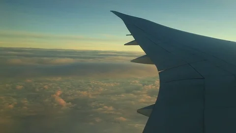 Window seat view of airline jet wing during a golden sunset. 動画素材 83654089