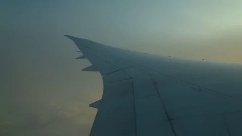 Window seat view of airline jet wing during a golden sunset. 動画素材 83654091