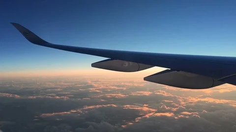 Window seat view of flight above clouds at beautiful sunrise. Stock-Footage 106545994