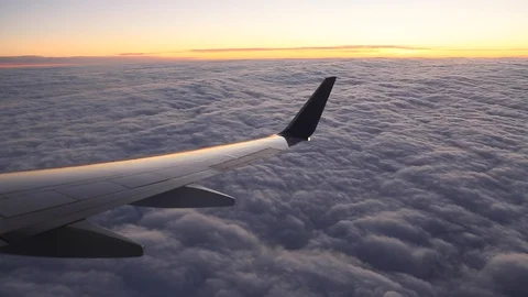 Window seat view out of a Delta airline at sunset. Plane is circling Stock Footage 128763038