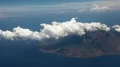 Window seat while flying over a small volcano island at a flight in Indonesia HD Footage