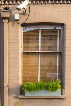 Window with security camera in dark cream wall Stock Photos