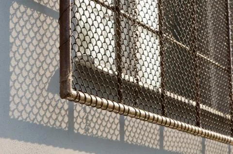 Window with security grate in soft sunlight light. Stock Photos