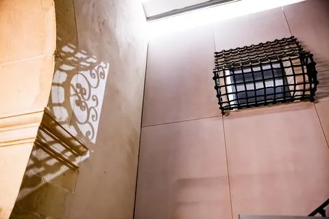 Window with the shadow of its grille on the wall in Alicante Foto stock