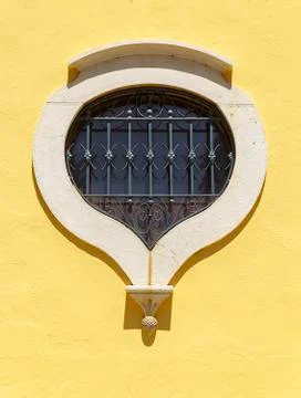 Window in the shape of a tear on a yellow wall, algarve Stock Photos