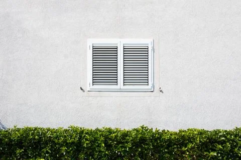 Window with shutters at the white wall Stock Photos