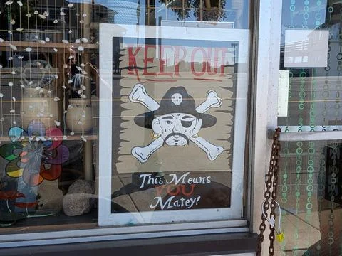 A window sign with pirate theme reading “Keep Out This Means You” Stock Photos