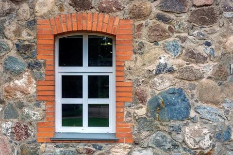 Window on a stone wall. Stock Photos