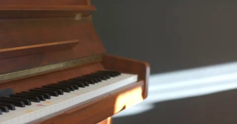 Window sunbeam is shifting on wall while camera is shifting focus across piano Stock Footage 344404176