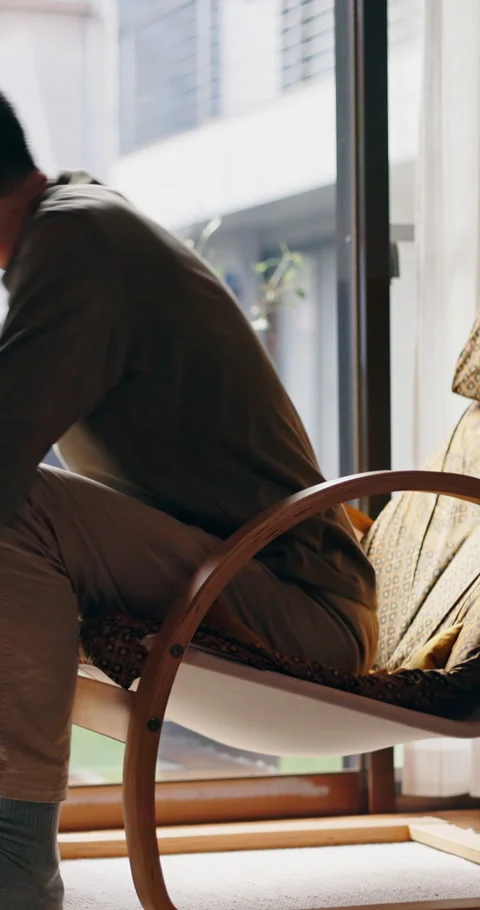 Window, thinking and Asian man relax in apartment with chair, contemplation and Stock Footage 341423604