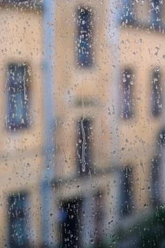 The window of the upper floor of the building bathed in drops of heavy rain Stock Photos