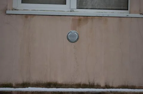 A window with a vent on the wall.  Stock Photos