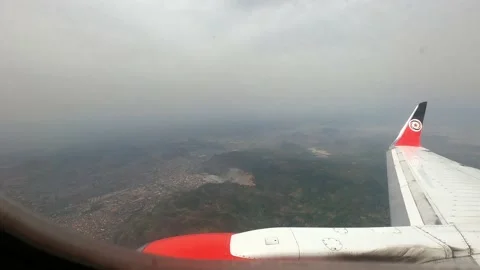 Window view - Aeroplane flying over mountain landscape in Africa Stock Footage 240015671