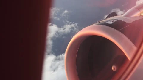 Window view of aircraft jet engine flying through blue sky and clouds. Stock Footage 345363863