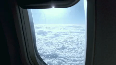 Window view from an airplane flying high in the sky above the clouds Stock Footage 278603699