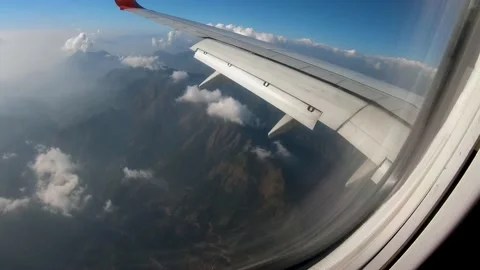 Window view airplane flying over the hilly region of Nepal while landing Stock Footage 130432585