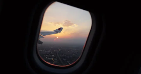 Window view of airplane gaining height just after take-off at sunset Video stock 327655368