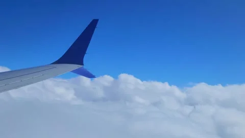 Window View From An Airplane Looking at the clouds and airplane wing Video stock 320022620