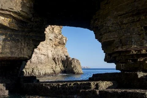 Window view on the cliffs and ocean at Farol do Cabo de Sao Vicente, Portugal Stock Photos