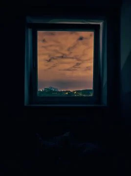 A window with a view of a cloudy sky at night Foto stock