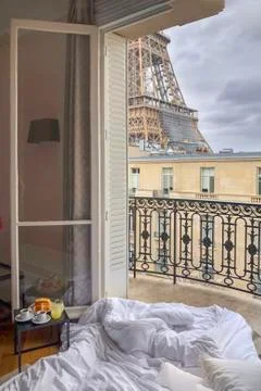 Window view of the Eiffel Tower with breakfast in a bed Stock Photos