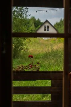 Window view to meadow and A frame cottage in rural Lithuania Stock Photos
