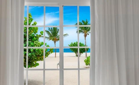 Window with a view of palm trees and a beach Foto stock