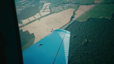 Window view of a small propeller aircraft making a turn in air flight above Stock Footage 202123881