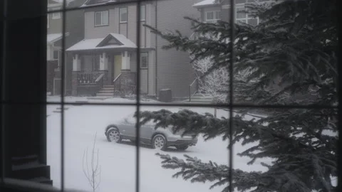 Window view of the snow falling outside on the suburban street Stock Footage 319810407