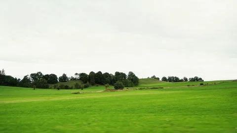 Window view from a train while passing meadows in Europe Stock Footage 98072111