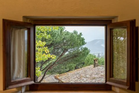 A window with a view of a tree and mountains in Italy Umbria Stock Photos