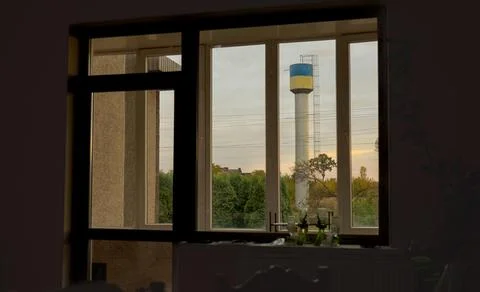 Window View of Water Tower at Sunset: Rustic Interior, Golden Light, Autumnal Stock Photos