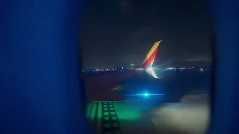 Window view of wing on runway after landing at night at Austin airport Видео 348793666