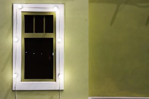 Window on the wall of a private house close-up, pistachio-colored walls Stock Photos