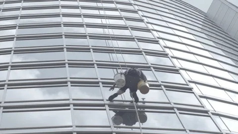 Window Washer cleaning directly above on skyscraper Stock Footage 91042963