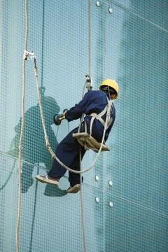 Window washer on side of skyscraper, close-up Fotos de archivo