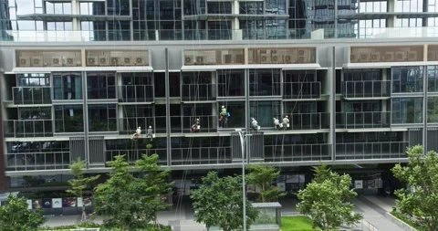 Window washers using industrial climbing techniques clean the facade of a high Stock Footage 289368564