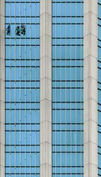 Window washers working on the glass facade of a skyscraper Stock Photos