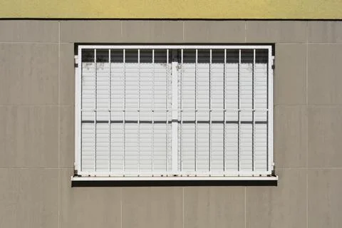 Window with white security bars and closed blinds Fotos Stock